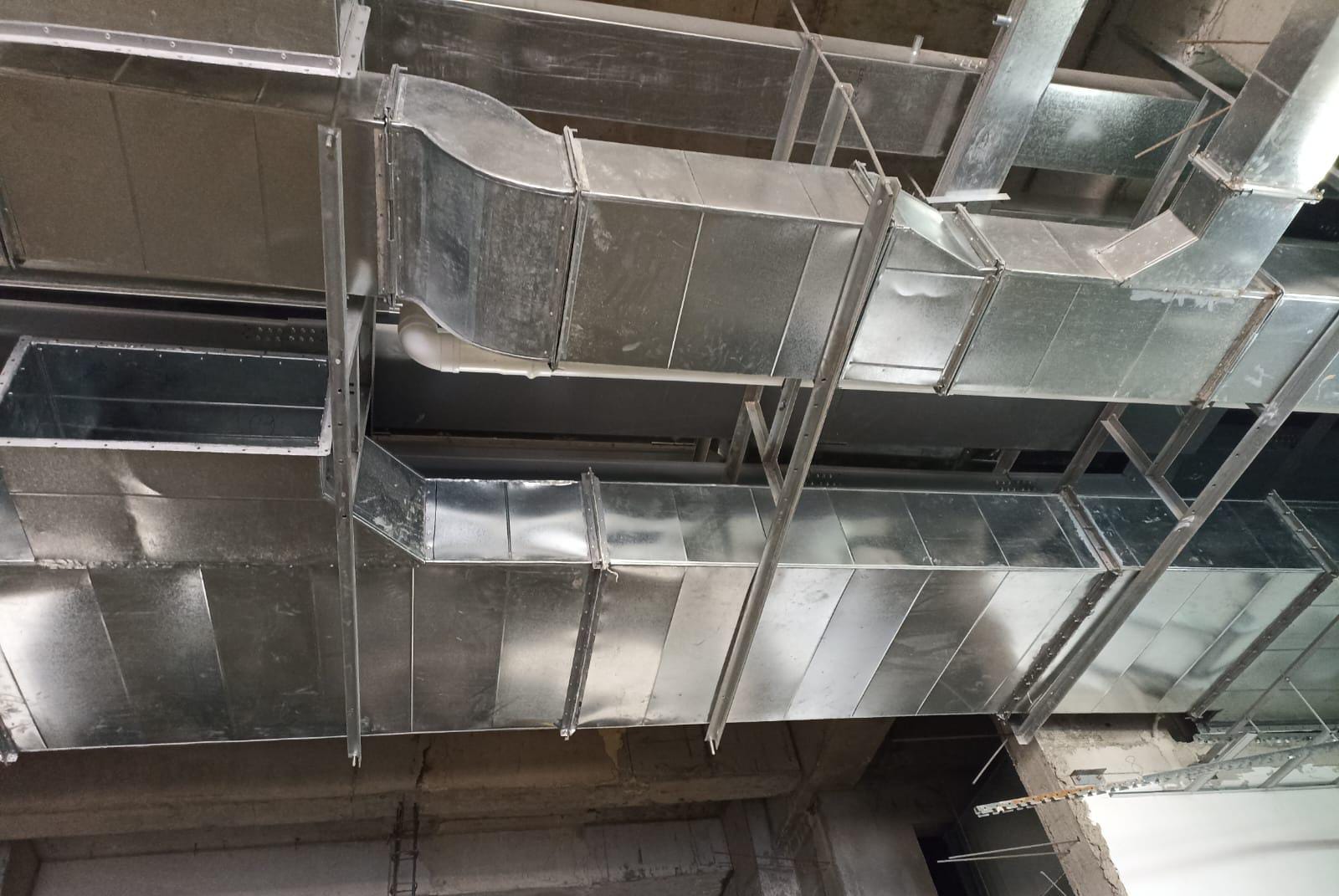 Galvanized sheet-metal ventilation ductwork installed on a concrete ceiling